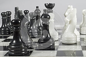 Attack of the black pieces in the course of a chess match. Marble chess board