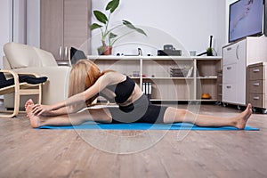 Attactive young woman being flexible during her home training