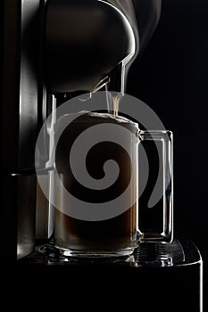 Atte in a glass cup on a dark background. Cappuccino, cooking, cup, glass, morning, breakfast, steam, hot drink, brewing,