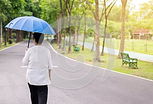 Attempt elderly asian woman holding umbrella walking to do workout while raining at public park
