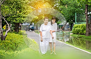 Attempt elderly asian woman walking to do workout with stick at public park,Daughter take care and support