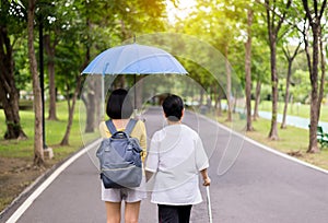 Attempt elderly asian women walking to do workout with stick at public park,Daughter take care and support