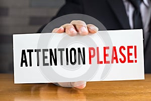 Attention please, message on white card and hold by businessman photo