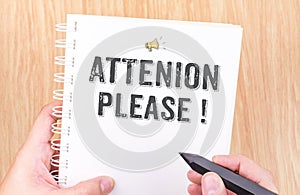 Attention please! word on white ring binder notebook with hand h