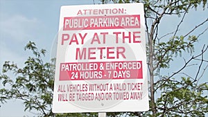 attention public parking area pay at the meter patrolled and enforced 24 hours..