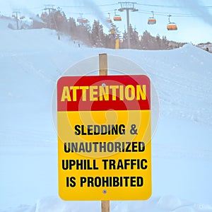 Attention sign against snow and chair lifts