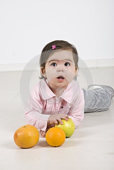 Attentive baby with fruits