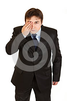 Attentive businessman closed eyes with his hand