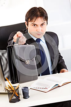 Attentive businessman giving briefcase