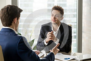 Attentive businessman listening to business partner talking duri photo