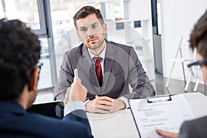 Attentive businessman listening to colleagues during job interview