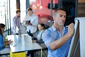 Attentive businessman writing on flip chart