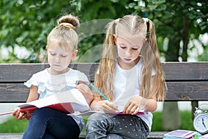 Attentive children draw in the schoolyard. The concept of school, study, education, friendship, childhood