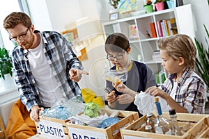 Attentive curious kids sorting out different kinds of trash