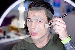 Attentive dark-haired guy with light green fitness watch