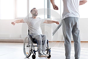 Attentive disabled man training in the gym with the orthopedist