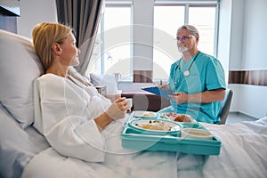 Attentive doctor listening to hospitalized patient complaints during ward round