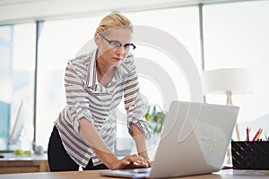 Attentive executive using laptop at desk