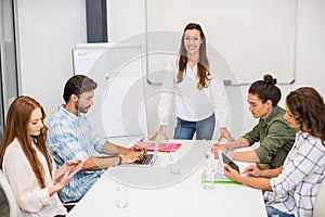 Attentive executive using laptop and digital tablet in conference room