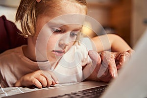 Attentive girl learning how to work with laptop