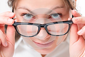 Attentive girl watching glasses having lowered