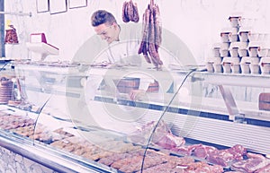 Attentive man cook cutting meat in butcher market