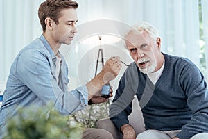 Attentive man giving drug to senior man