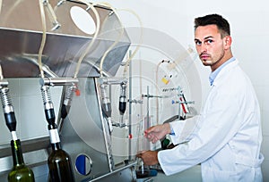 Attentive man making tests in wine manufactory laboratory