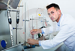 Attentive man making tests in wine manufactory laboratory