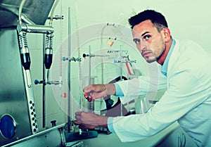 Attentive man making tests in wine manufactory laboratory