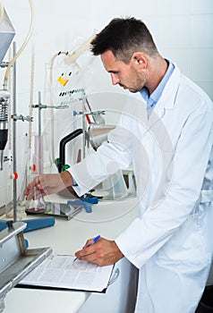 Attentive man making tests in wine manufactory laboratory