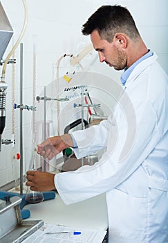 Attentive man making tests in wine manufactory laboratory