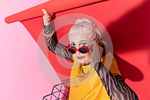 Attentive mature woman sitting isolated on red