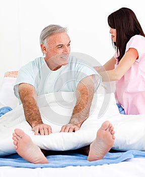 Attentive nurse fixing her patient's bed