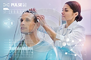 Attentive nurse touching wires while checking them before making EEG photo