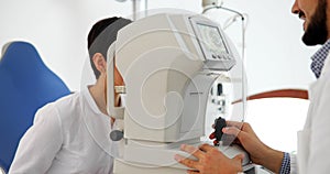 Attentive optometrist examining female patient on slit lamp