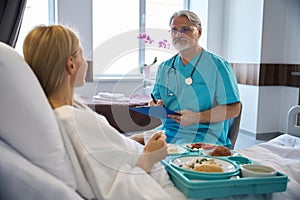 Attentive physician listening to patient complaints during ward round