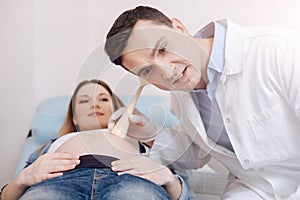 Attentive physician providing pregnant belly examination in the clinic