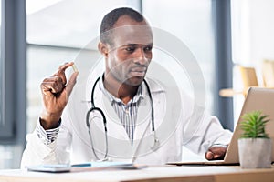 Attentive practitioner staring at laptop