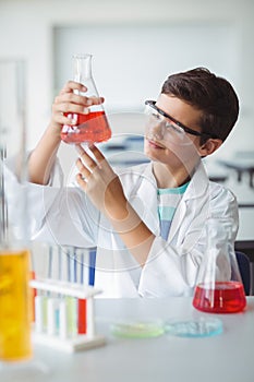 Attentive schoolboy doing a chemical experiment in laboratory