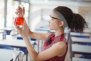 Attentive schoolgirl doing a chemical experiment in laboratory