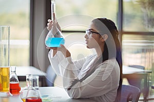 Attentive schoolgirl doing a chemical experiment in laboratory