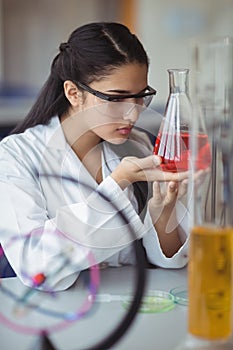 Attentive schoolgirl doing a chemical experiment in laboratory