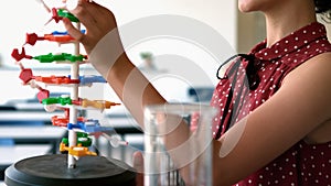 Attentive schoolgirl experimenting molecule model in laboratory