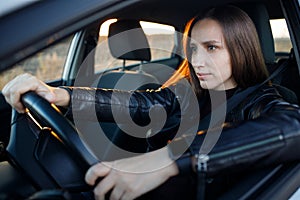 Attentive and stylish female driver in the car