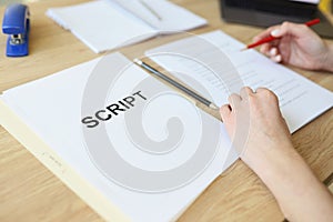 Attentive woman reads script papers editing text with pencil photo