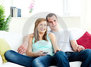 Attentive young couple watching tv on the sofa