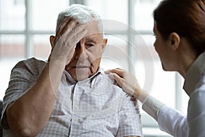 Attentive young lady physician interview senior patient listen to complaints