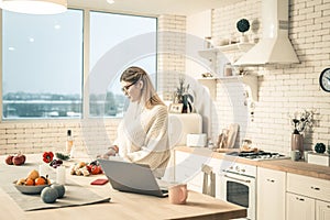 Attentive young woman cooking on tidy kitchen