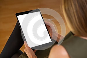 Attentive young woman holding tablet with white screen in vertical orientation